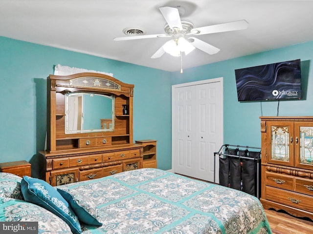 bedroom with ceiling fan, a closet, and wood-type flooring