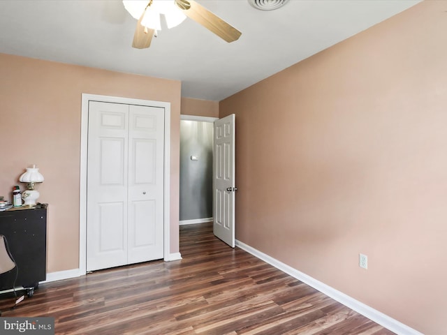 unfurnished bedroom featuring a closet, ceiling fan, and dark hardwood / wood-style flooring