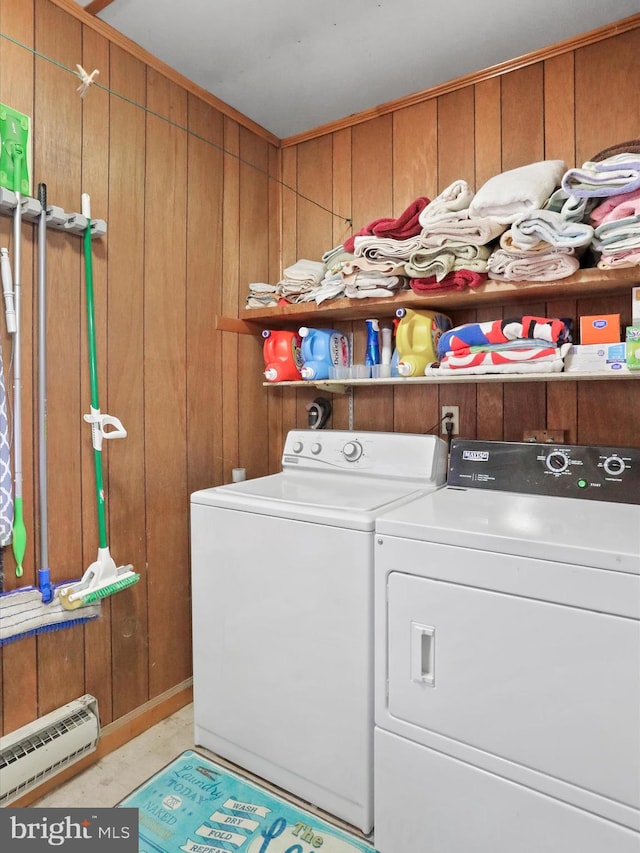 laundry area with separate washer and dryer, baseboard heating, and wooden walls