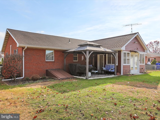 rear view of property with a gazebo, a yard, and a patio