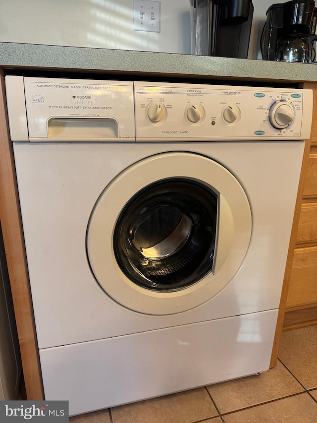 clothes washing area featuring tile patterned flooring and washer / dryer