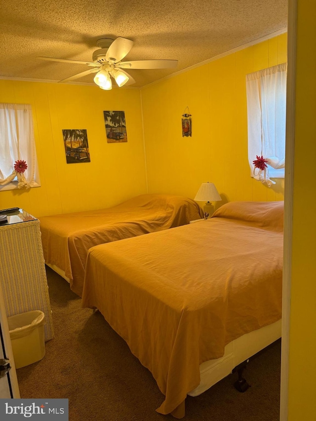 bedroom featuring dark colored carpet, a textured ceiling, and ceiling fan