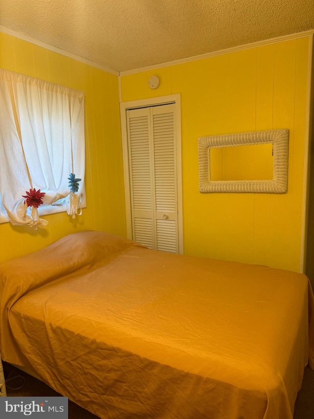 unfurnished bedroom featuring ornamental molding, a textured ceiling, and a closet