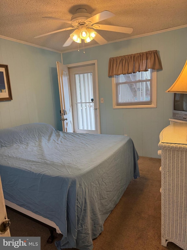 bedroom with ceiling fan, crown molding, carpet floors, and a textured ceiling