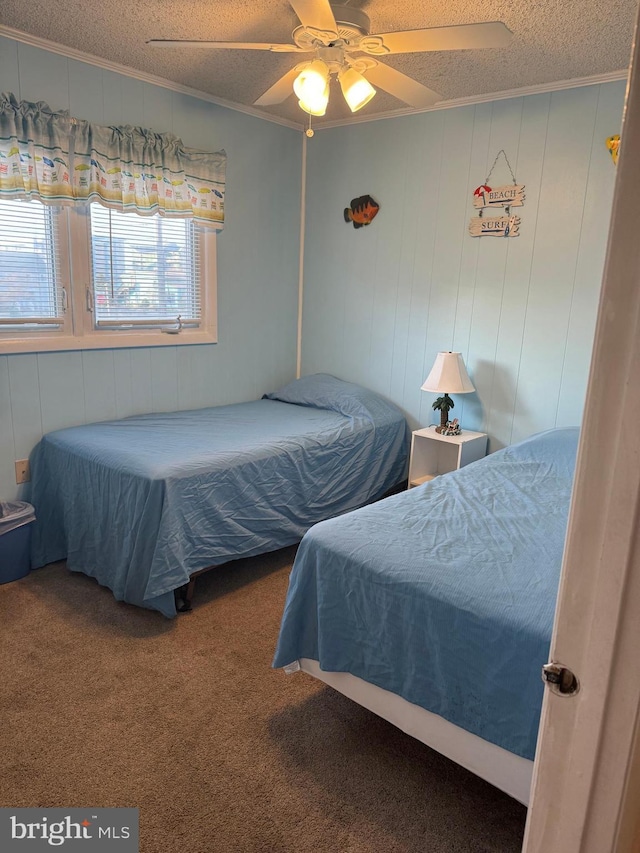 carpeted bedroom with ceiling fan, wood walls, crown molding, and a textured ceiling