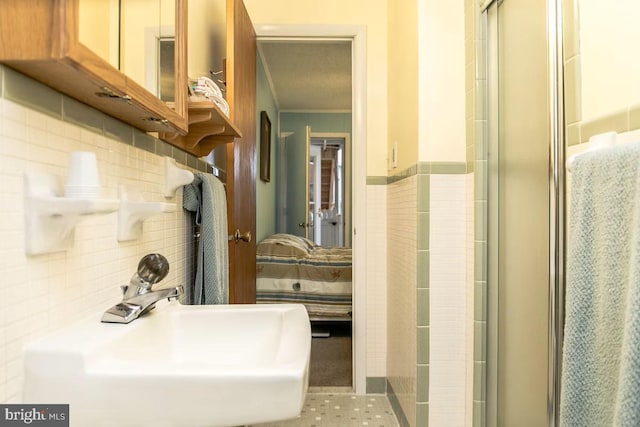 bathroom with decorative backsplash, sink, and walk in shower