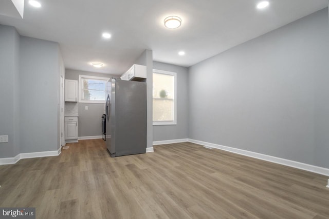 kitchen featuring white cabinetry, light wood-type flooring, and stainless steel refrigerator