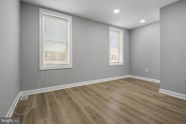 unfurnished room with hardwood / wood-style flooring and a wealth of natural light