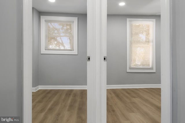 corridor with light hardwood / wood-style floors and a wealth of natural light