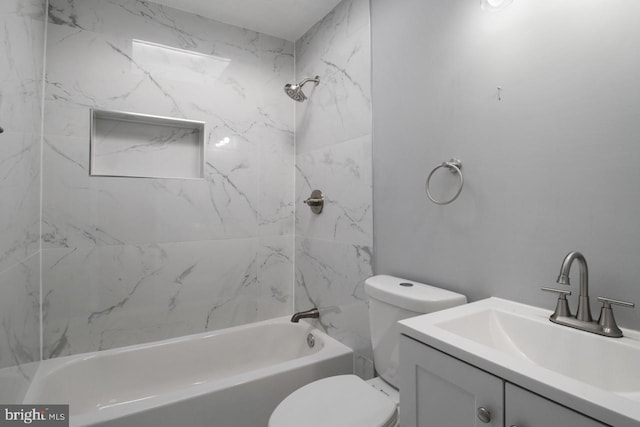 full bathroom featuring vanity, tiled shower / bath combo, and toilet