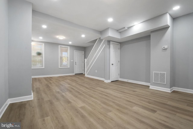 basement with light hardwood / wood-style flooring