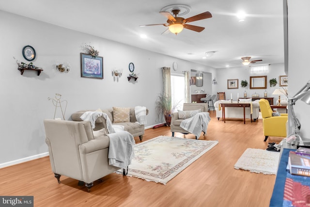 living room with light hardwood / wood-style floors and ceiling fan