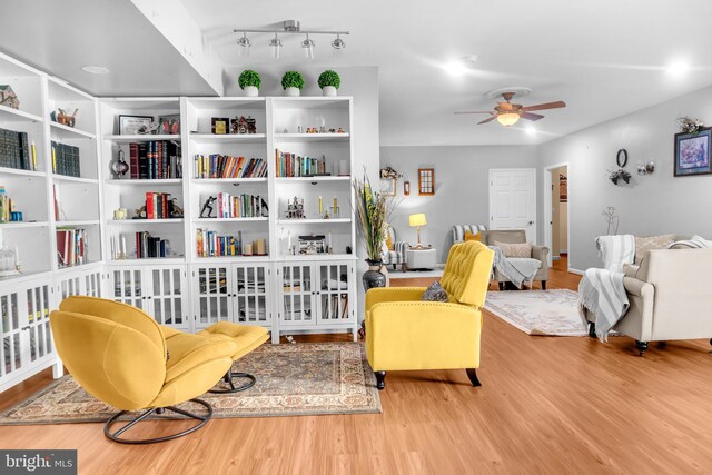 living area with light hardwood / wood-style floors and ceiling fan