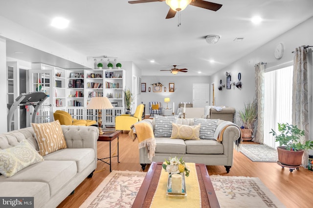 living room with light hardwood / wood-style flooring and ceiling fan