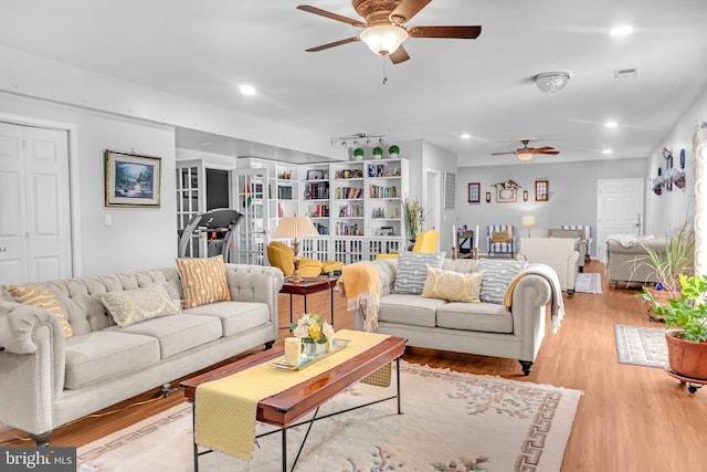 living room with ceiling fan and light hardwood / wood-style floors