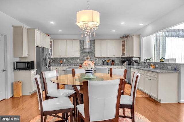 kitchen featuring light wood-type flooring, stainless steel appliances, sink, pendant lighting, and a center island