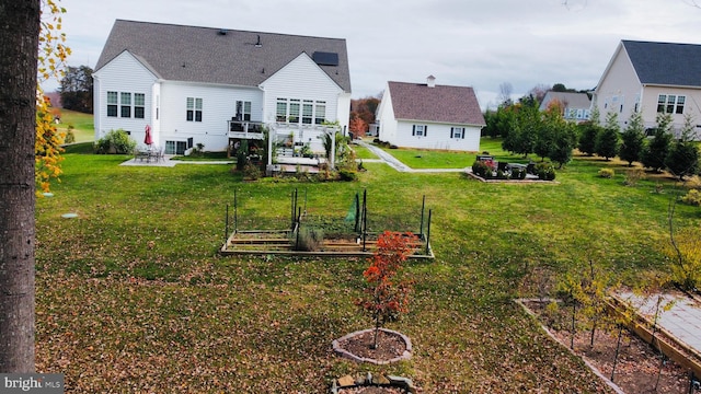 back of house featuring a yard, an outdoor fire pit, a patio area, and a wooden deck