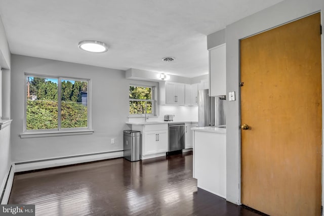 kitchen with a baseboard radiator, sink, dark hardwood / wood-style flooring, white cabinetry, and stainless steel appliances