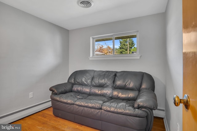 living room featuring a baseboard radiator and light hardwood / wood-style flooring