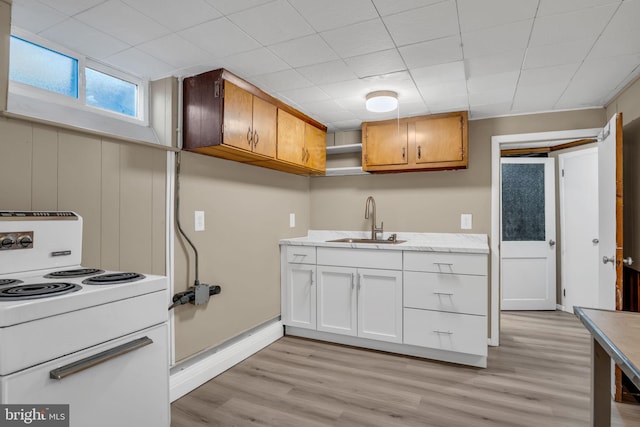 kitchen with white cabinetry, sink, electric range, and light wood-type flooring