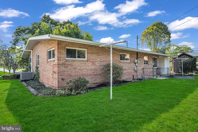 rear view of house with a yard and cooling unit