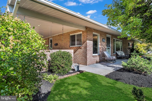 exterior space with a patio area and a lawn