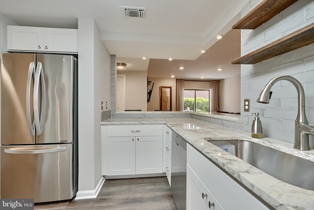 kitchen with appliances with stainless steel finishes, dark hardwood / wood-style flooring, tasteful backsplash, sink, and white cabinetry