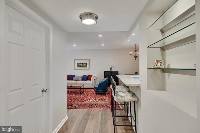 corridor featuring hardwood / wood-style floors and an inviting chandelier