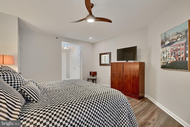 bedroom with ceiling fan, a closet, and light hardwood / wood-style floors