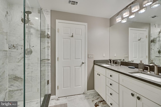 bathroom featuring a shower with door and vanity