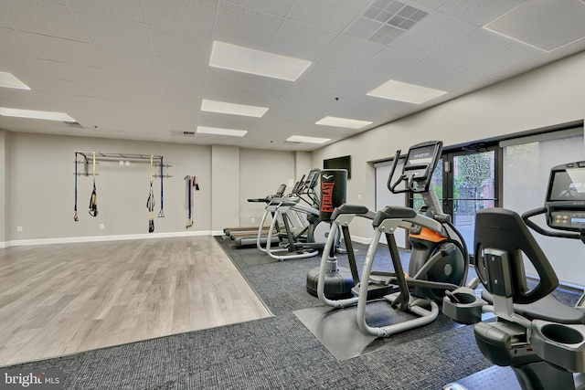 workout area featuring a drop ceiling and wood-type flooring