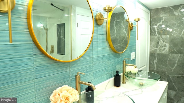 bathroom featuring vanity, tasteful backsplash, and tile walls