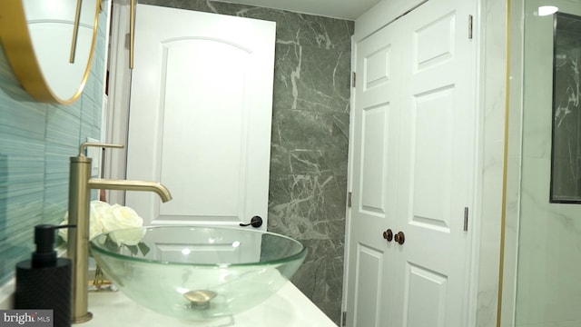 bathroom with vanity and tile walls