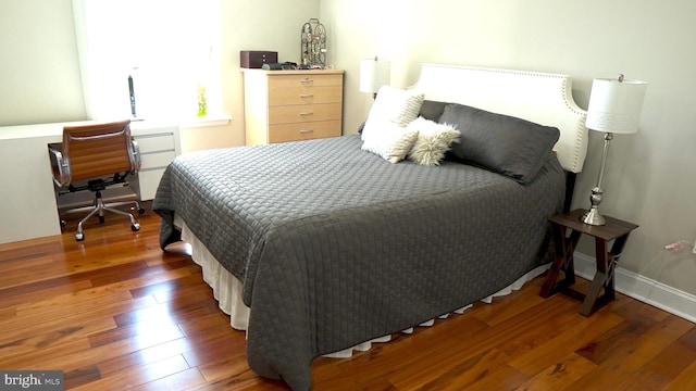 bedroom with dark hardwood / wood-style flooring