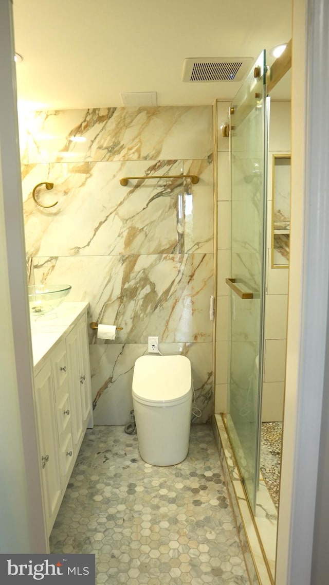 bathroom featuring vanity, a shower with shower door, toilet, and tile walls