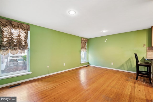 unfurnished room with hardwood / wood-style flooring