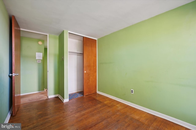 unfurnished bedroom featuring dark hardwood / wood-style floors and a closet