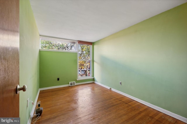 unfurnished room with hardwood / wood-style flooring