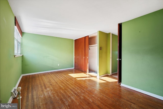 unfurnished bedroom featuring wood-type flooring and a closet