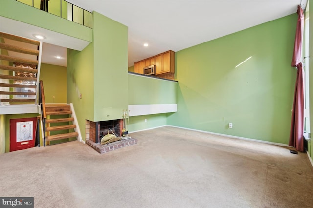 unfurnished living room featuring light carpet and a brick fireplace