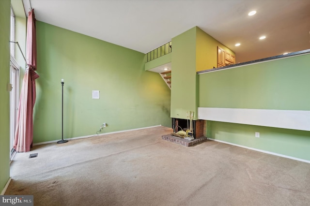 unfurnished living room with carpet flooring and a fireplace