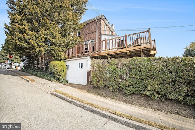 view of property exterior with a wooden deck