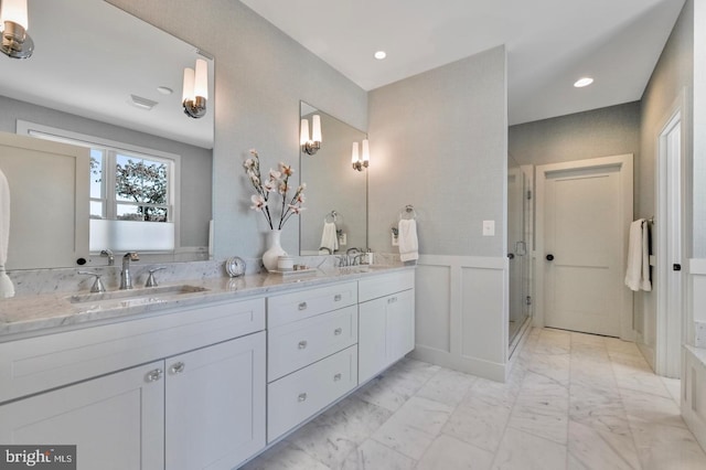 bathroom with a shower with door and vanity