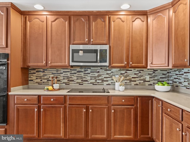 kitchen featuring black appliances and tasteful backsplash