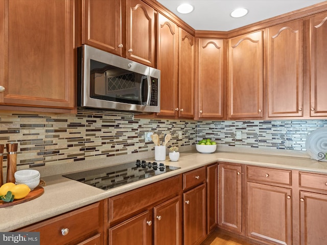 kitchen with black electric cooktop and tasteful backsplash