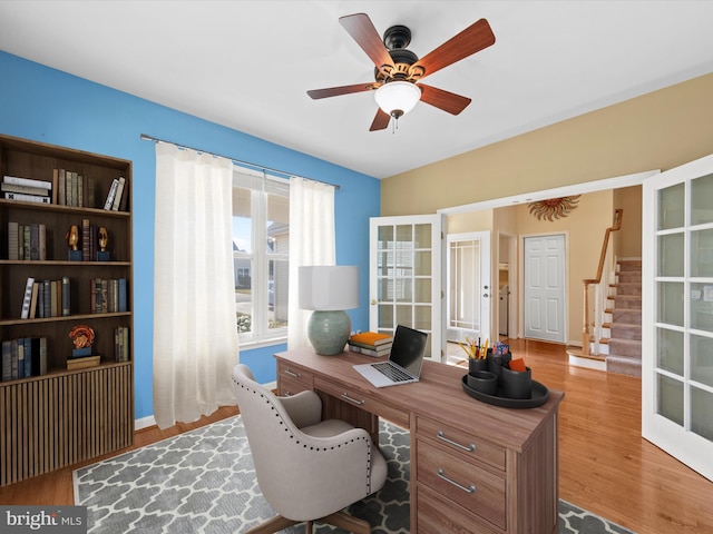 home office with hardwood / wood-style floors, ceiling fan, and french doors