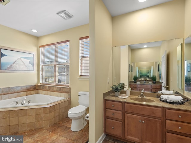 bathroom featuring toilet, vanity, and tiled tub