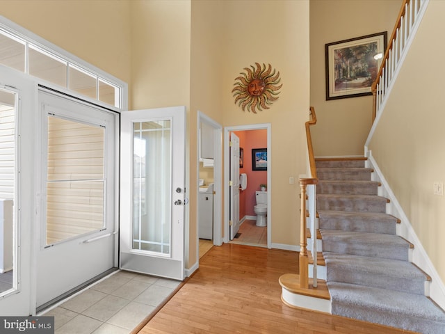 entryway with light hardwood / wood-style floors and a high ceiling