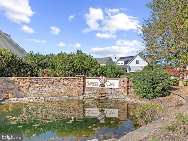 community / neighborhood sign with a water view