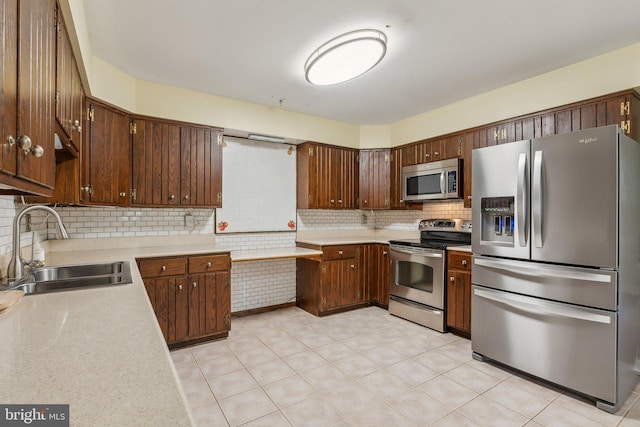 kitchen with stainless steel appliances, sink, and decorative backsplash